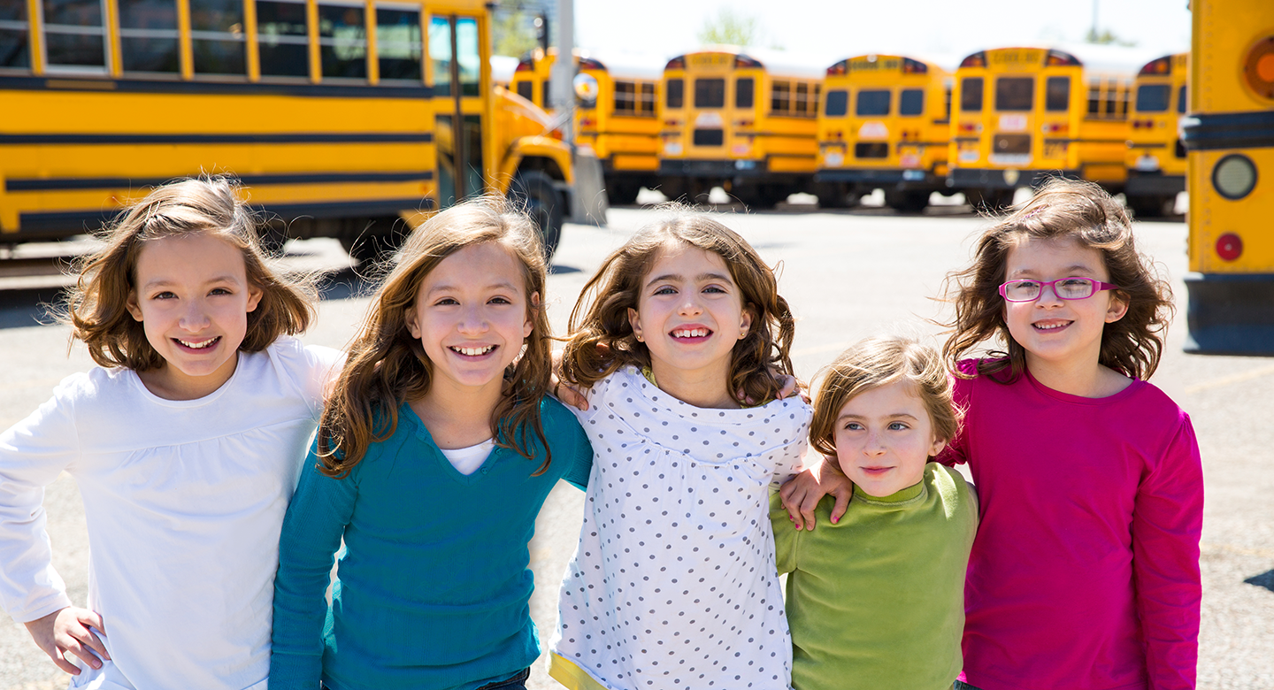 Photo: 5 students near bus fleet